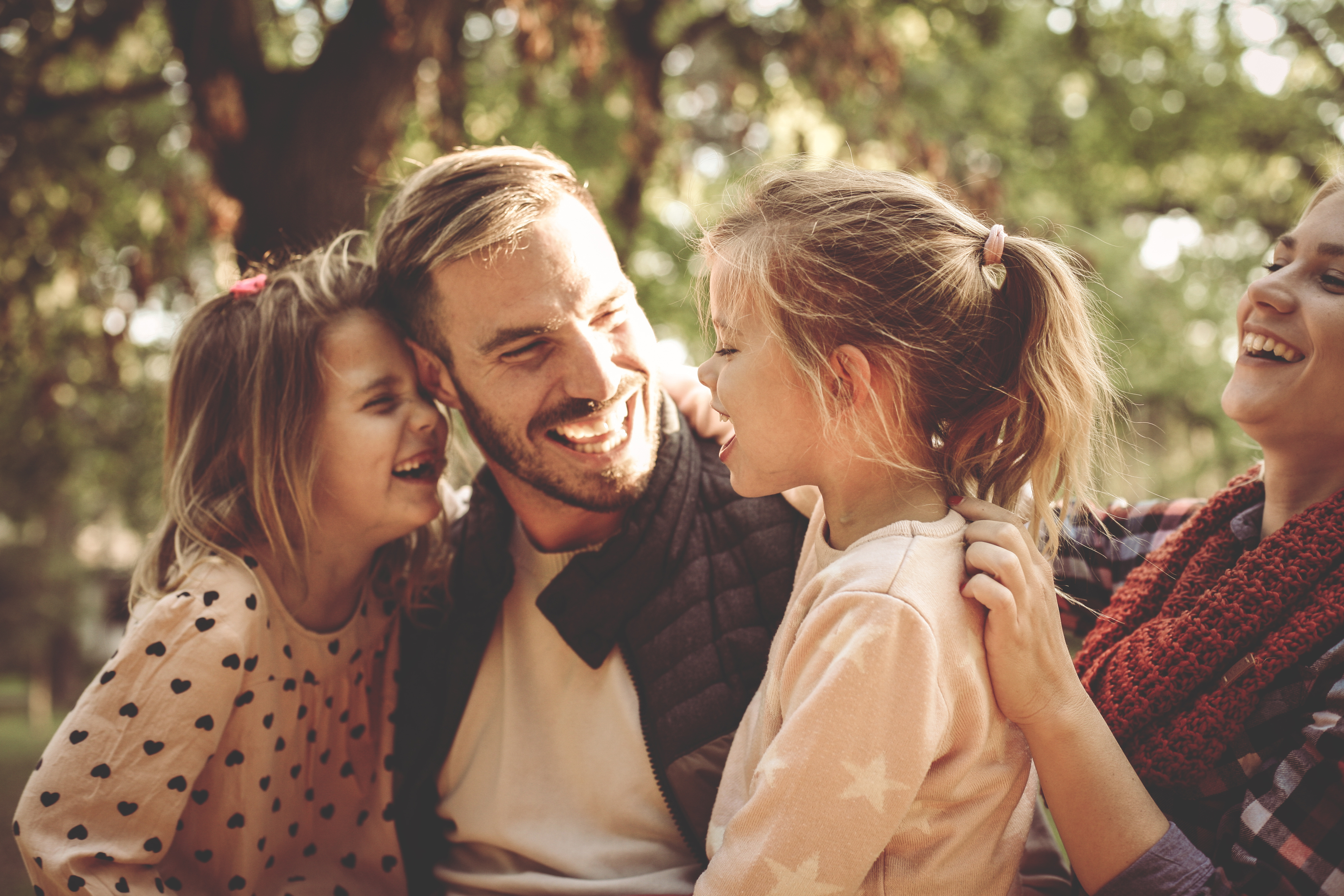 En mamma, pappa och två döttrar skrattar