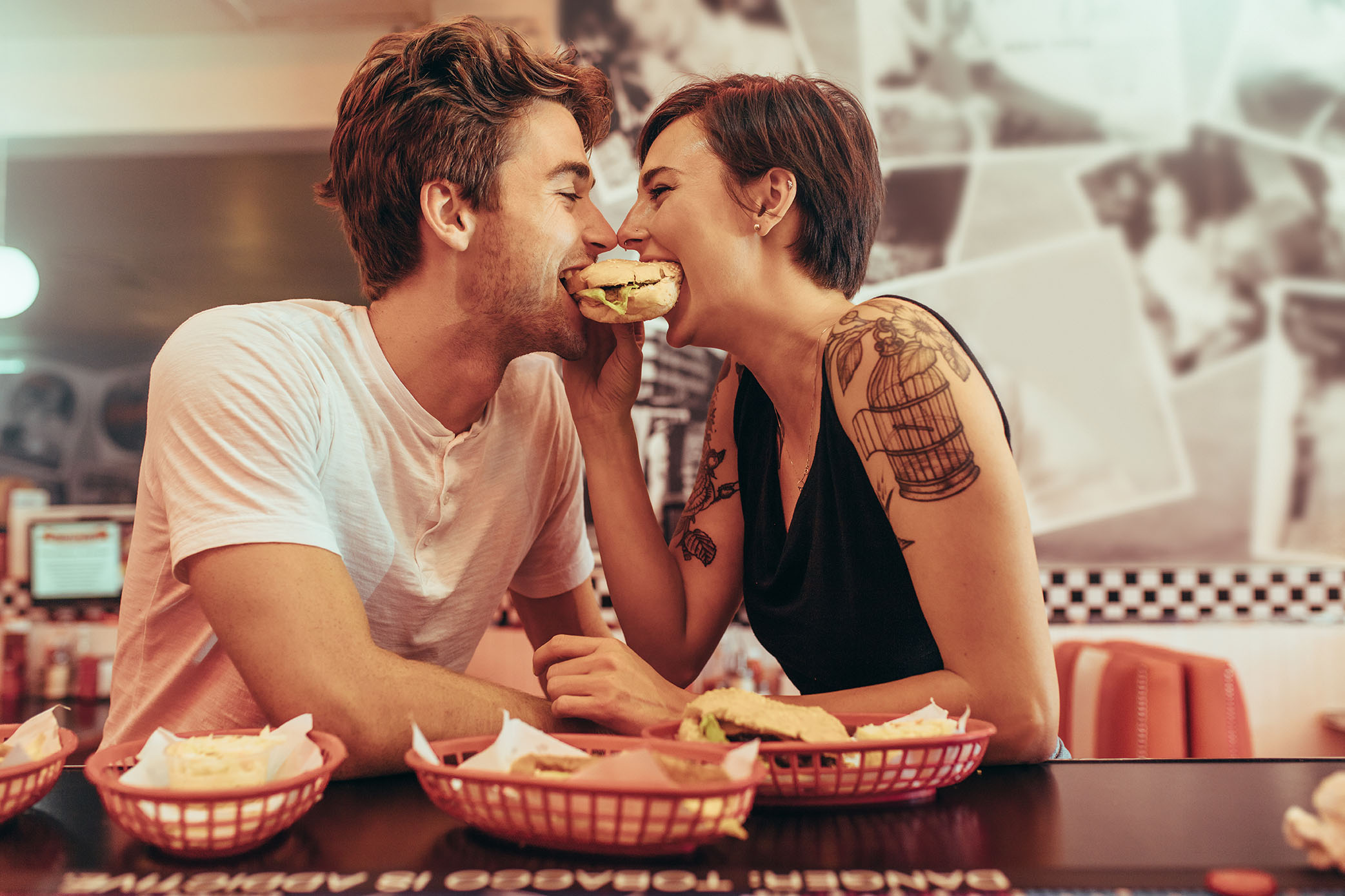 En man och en kvinna äter en hamburgare tillsammans