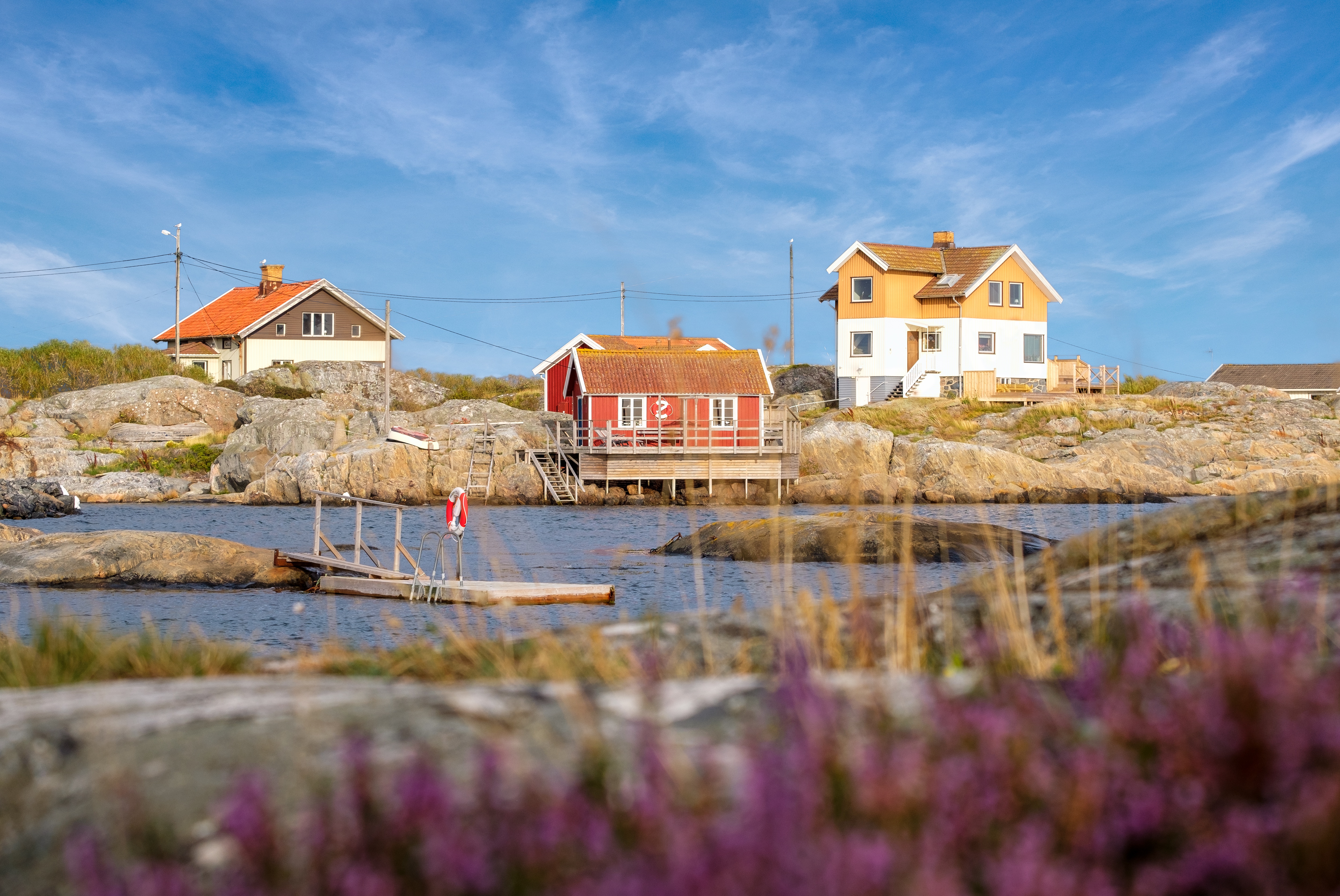 Ett skärgårdslandskap med trästugor i olika färg
