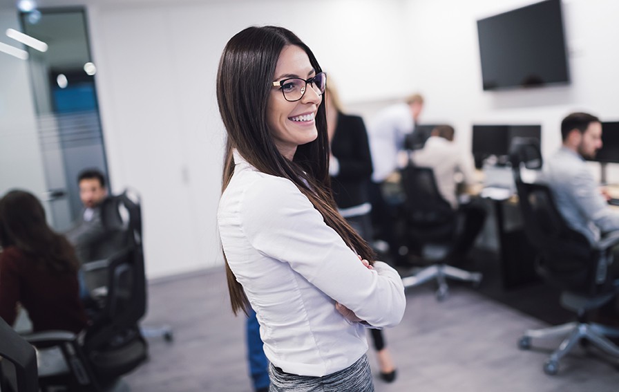Kvinna som ler på sin arbetsplats