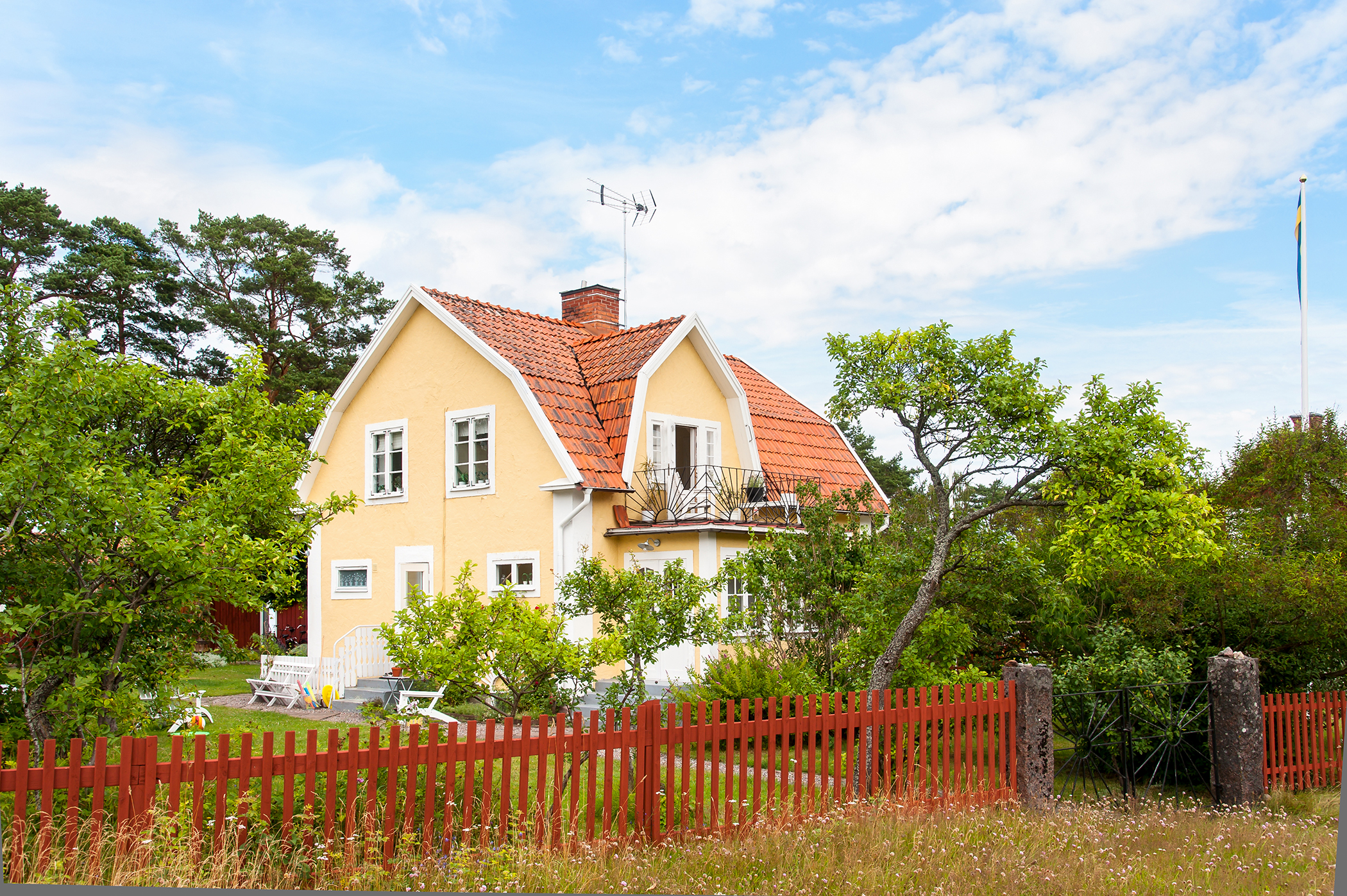 En gul villa med en stor trädgård