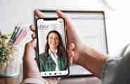 Hemskärmen på en mobiltelefon visar Lexlys hemsida med en leende kvinna