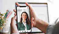 Hemskärmen på en mobiltelefon visar Lexlys hemsida med en leende kvinna