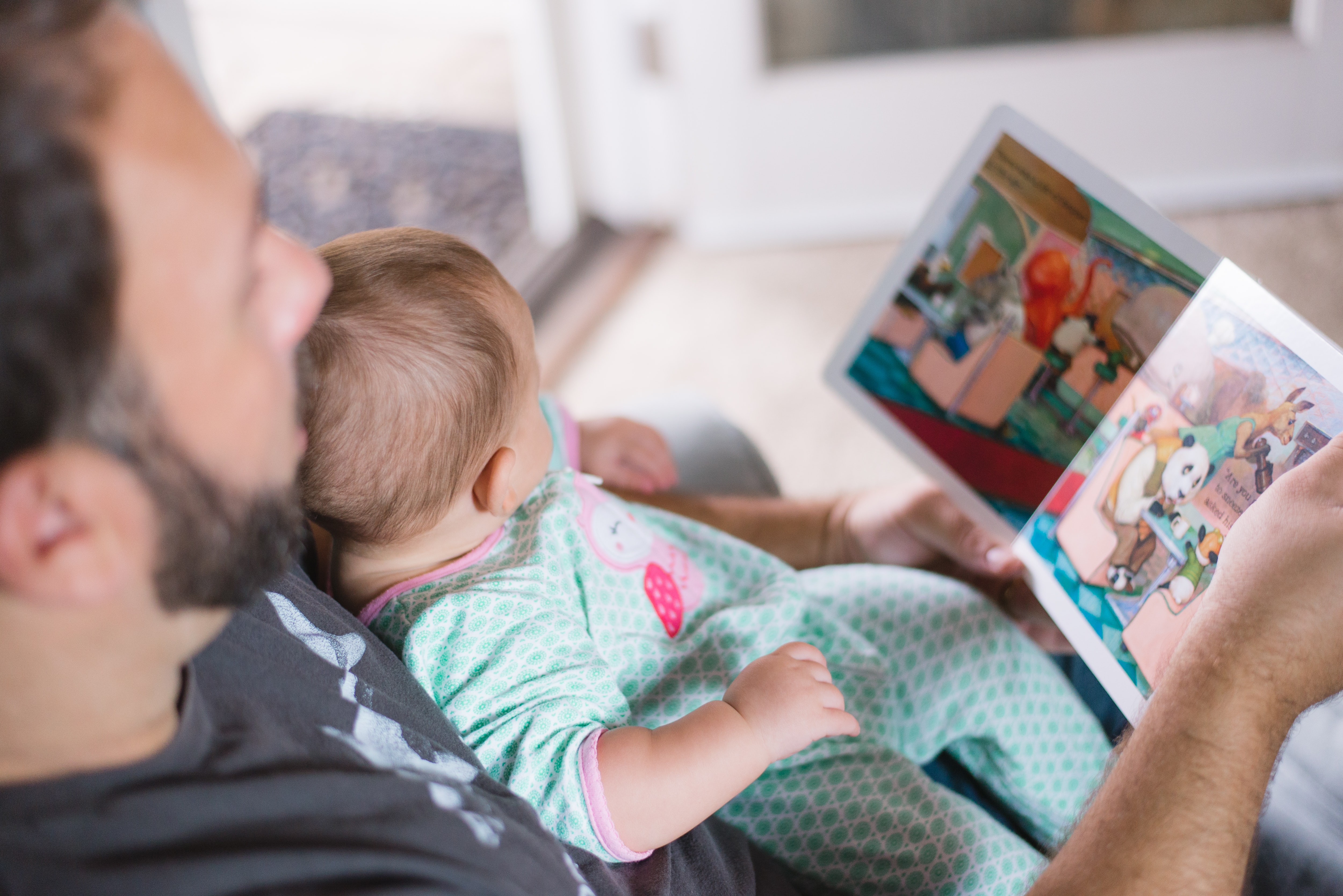 En förälder läser en bok för sin bebis