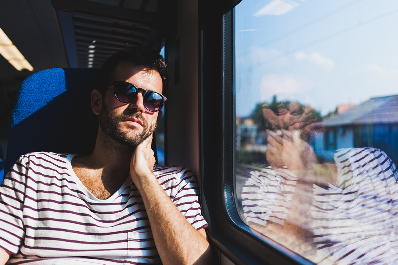 En ensam man sitter på ett tåg