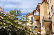 Bild på husfasad med balkonger i solsken