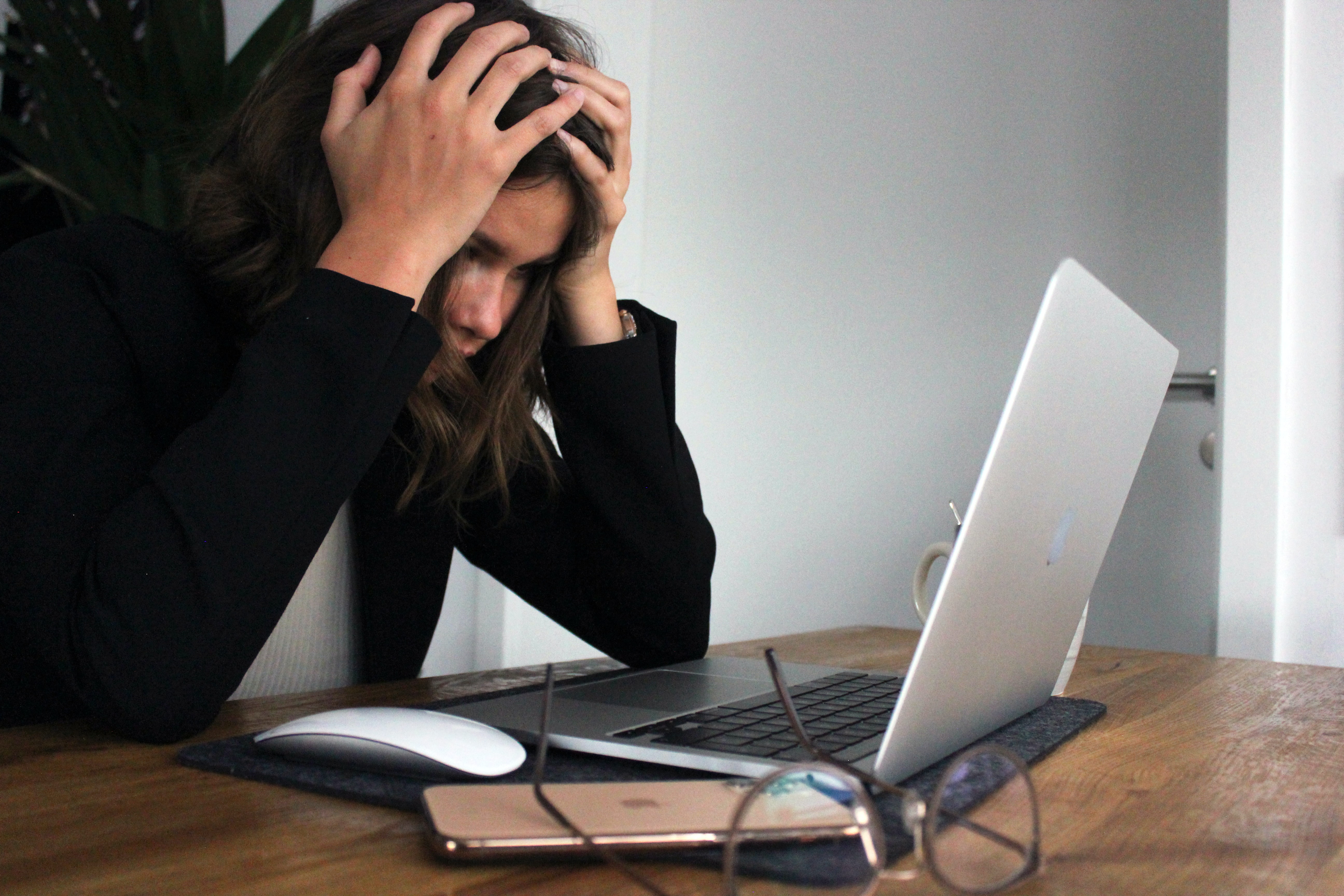 En kvinna är frustrerad framför sin dator